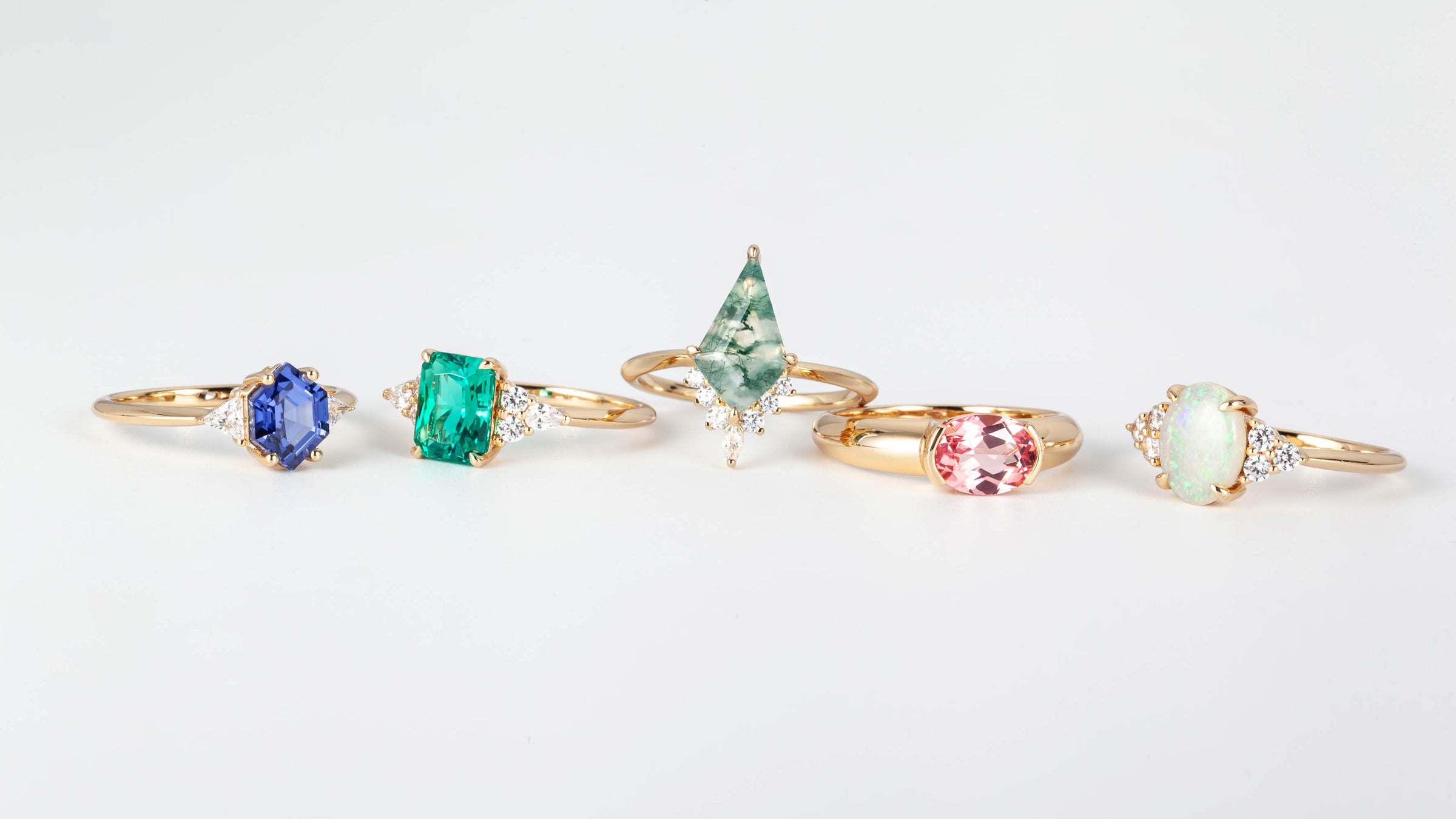 A Collection of gemstone engagement rings in 18k gold and various kinds of gems